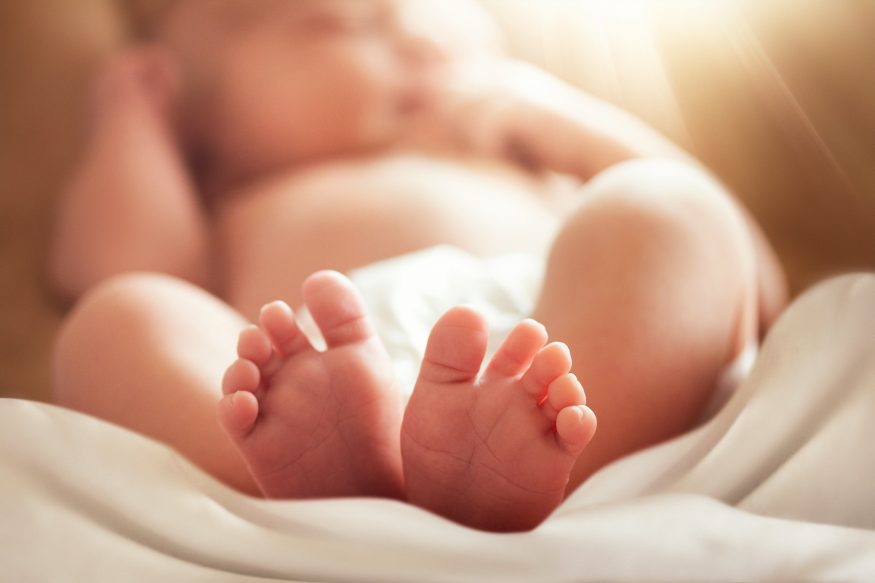 feet of newborn baby with soft blur effect, motherhood theme conceptual photo