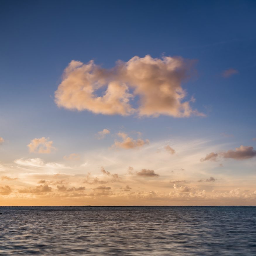 Dramatic clouds at sunset over the horizon of the Pacific Ocean, Cook Islands, background with copy
